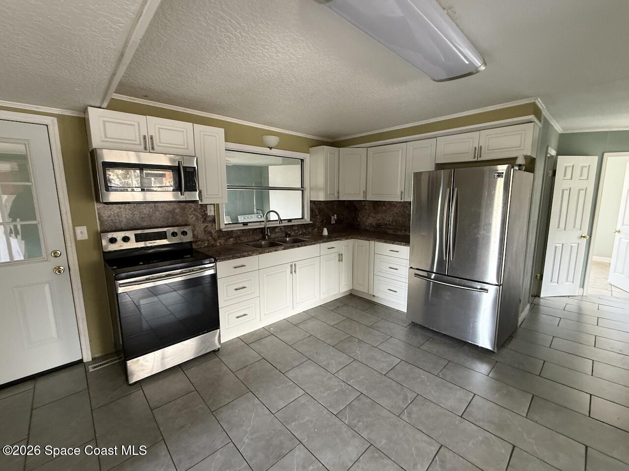 1666 Terrace Street Cocoa, FL 32922 - Photo 3 of 12 a kitchen with granite countertop a refrigerator and a stove top oven