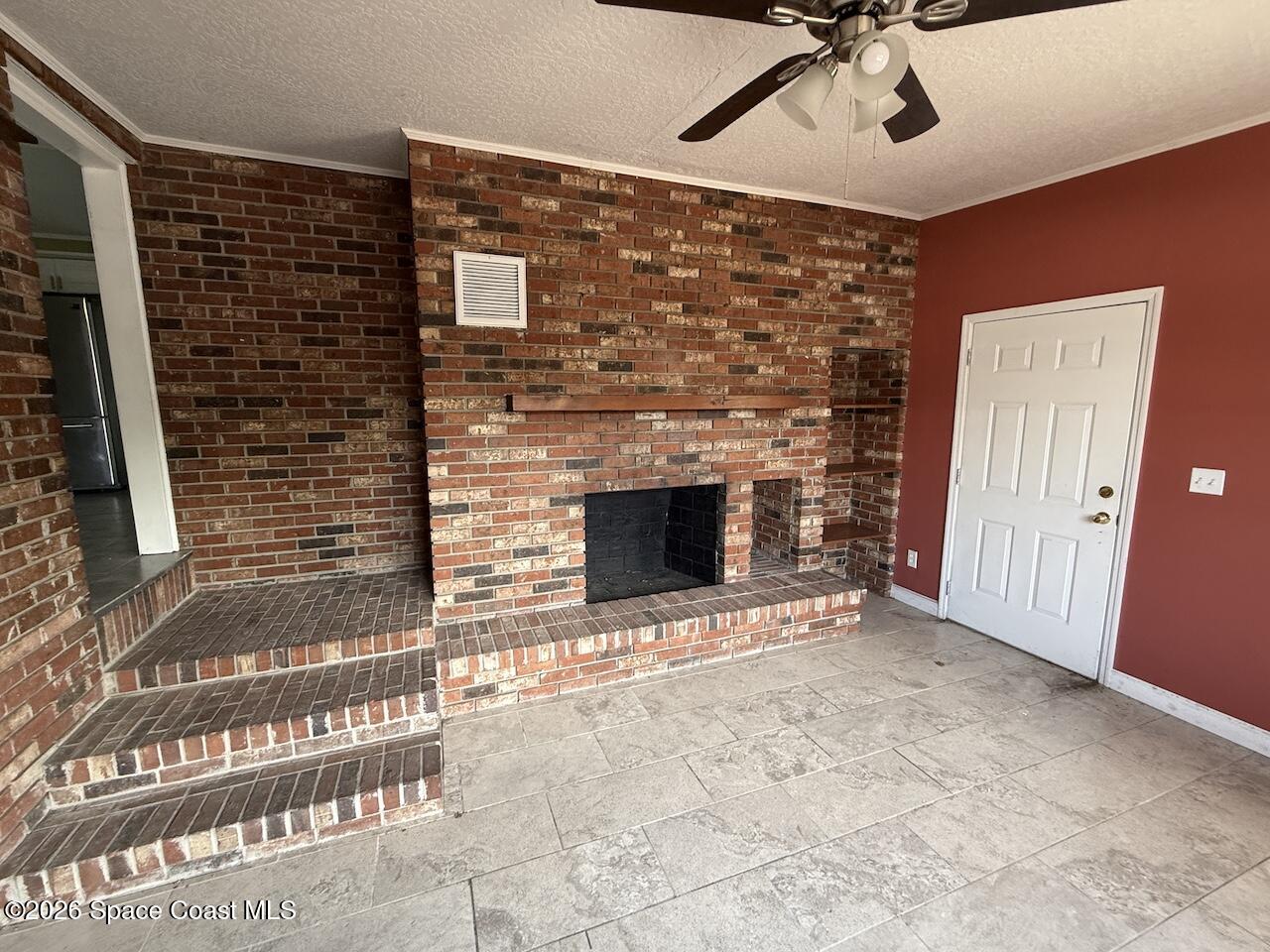 1666 Terrace Street Cocoa, FL 32922 - Photo 4 of 12 a view of an empty room with a fireplace and fan