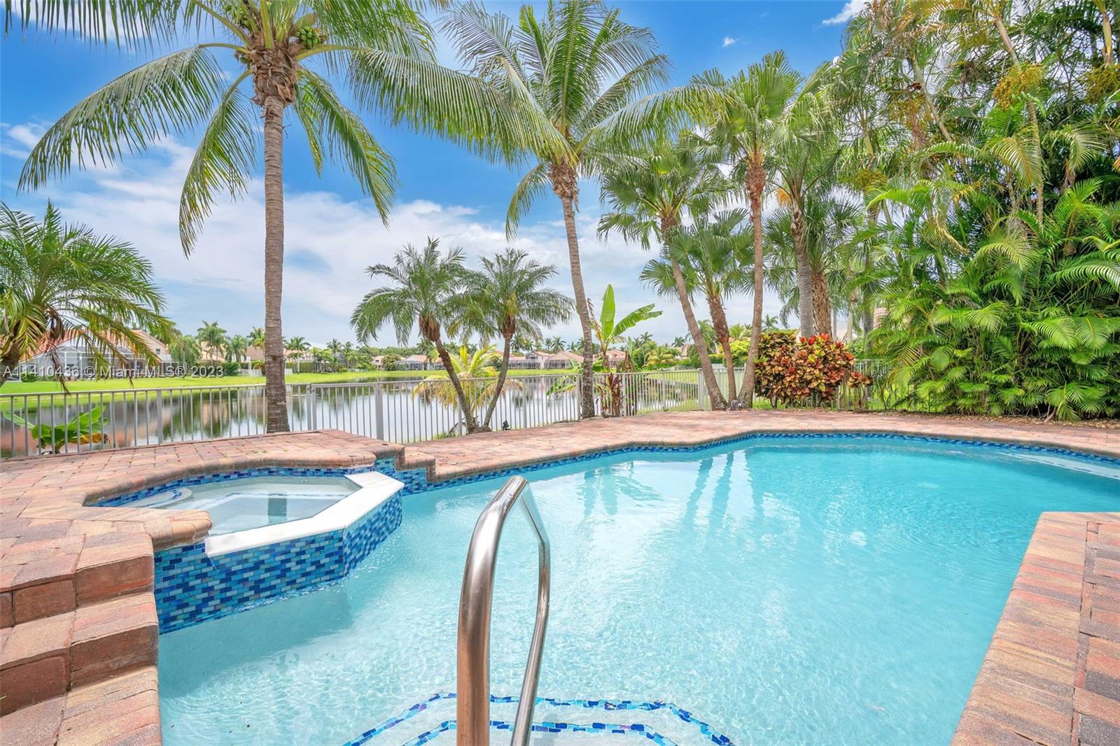 19440 Preserve Drive Boca Raton, FL 33498 - Photo 3 of 69 a view of a swimming pool with a lawn chairs under palm trees