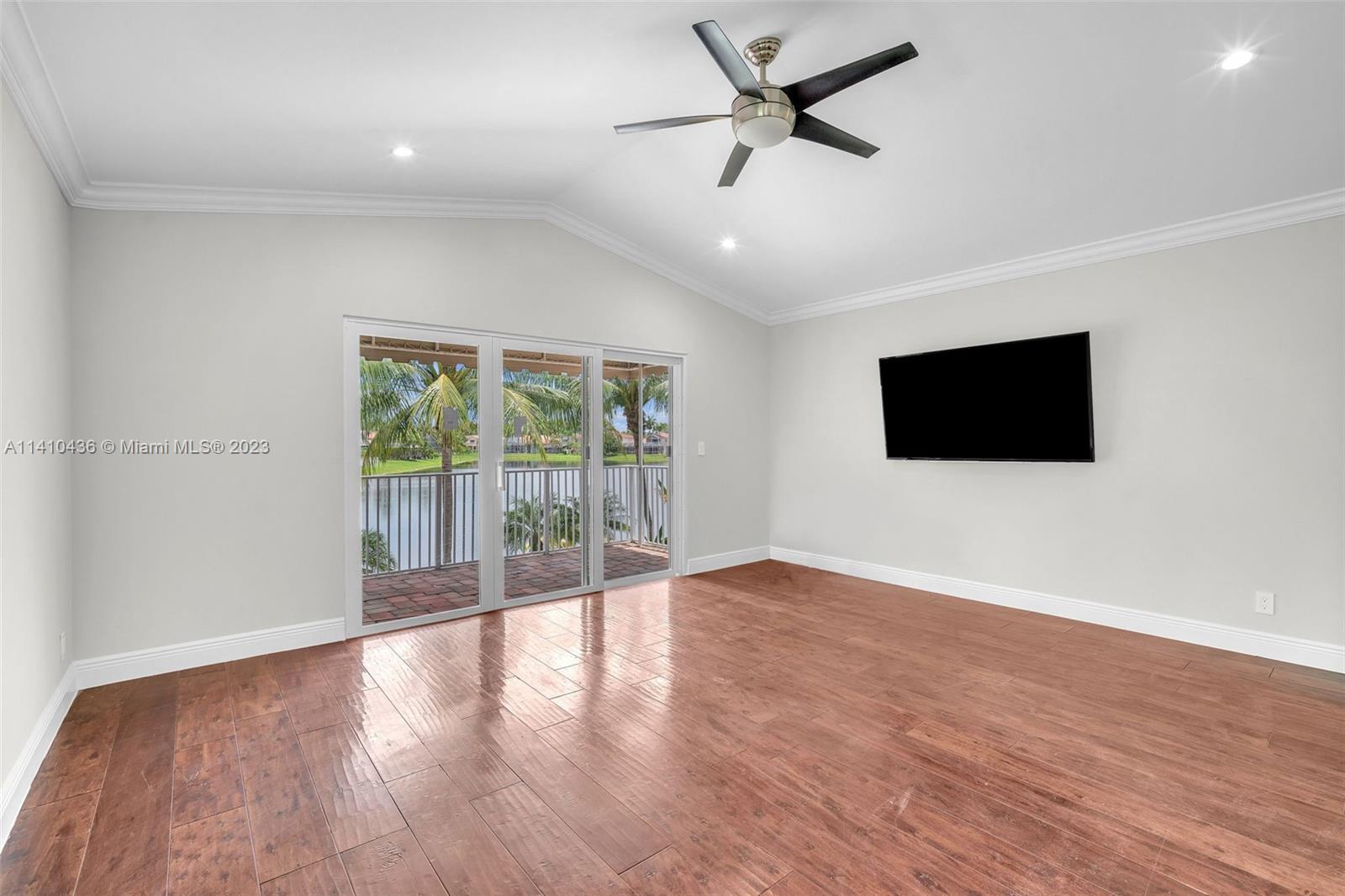 19440 Preserve Drive Boca Raton, FL 33498 - Photo 33 of 69 a view of an empty room with wooden floor and a flat screen tv