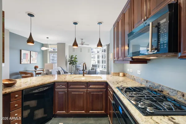 a kitchen with stainless steel appliances granite countertop a stove a sink and a wooden floors
