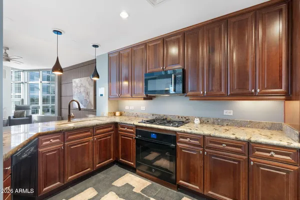 a kitchen with stainless steel appliances granite countertop wooden cabinets a sink and dishwasher