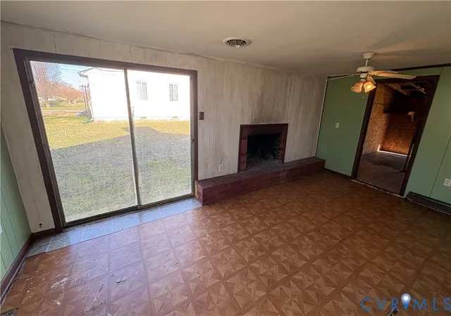 a view of an empty room with a fireplace and a window
