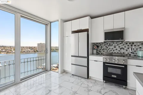 a kitchen with granite countertop a refrigerator a stove a washer and dryer