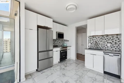 a kitchen with granite countertop a refrigerator and a stove top oven