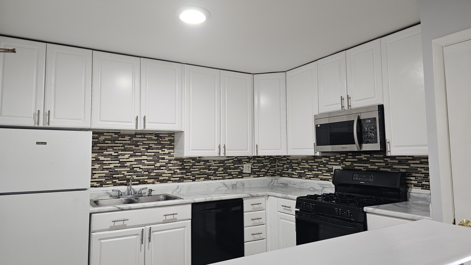 9588 Terrace Place, Unit 1C Des Plaines, IL 60016 - Photo 8 of 13 a kitchen with granite countertop white cabinets and black appliances