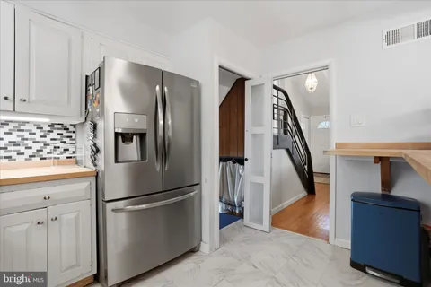a metallic refrigerator freezer sitting inside of a kitchen
