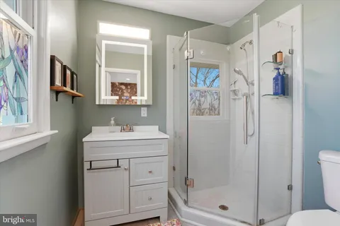 a bathroom with a shower sink and mirror