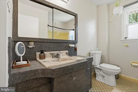 a bathroom with a granite countertop toilet sink and mirror