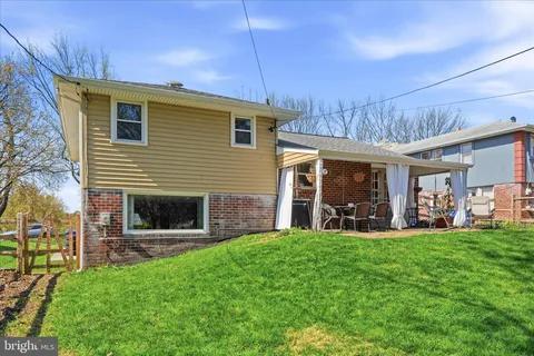 a view of a house with a yard and sitting area