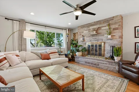 a living room with furniture ceiling fan and a large window