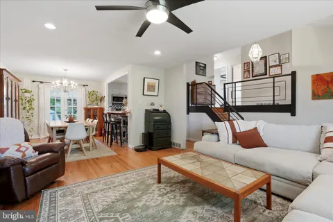 a living room with furniture kitchen view and a wooden floor