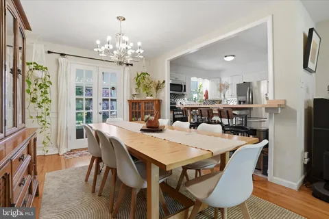a view of a dining room with furniture a chandelier and wooden floor