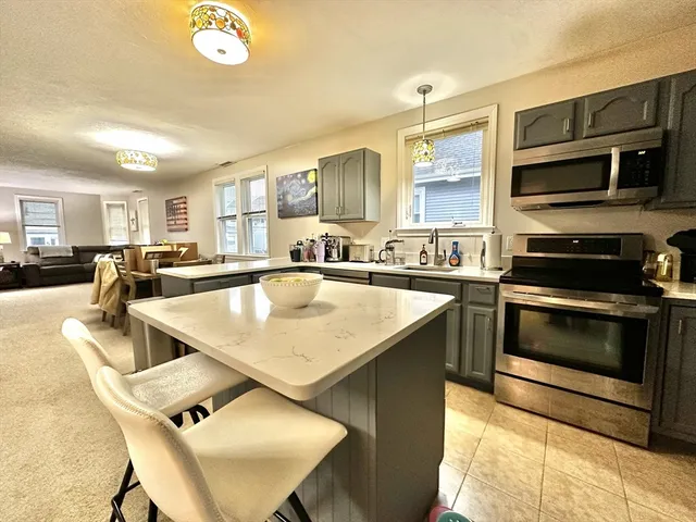 a kitchen with kitchen island a white counter top space a sink and appliances