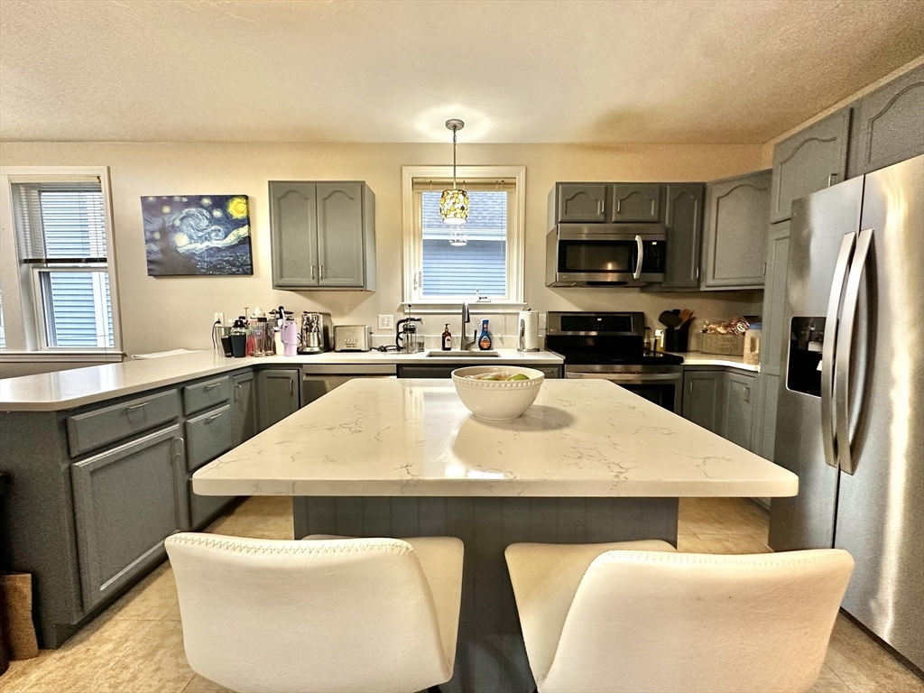 47-49 Botolph Street, Unit 49 Quincy, MA 02171 - Photo 6 of 14 a kitchen with kitchen island a white counter top space a sink and appliances