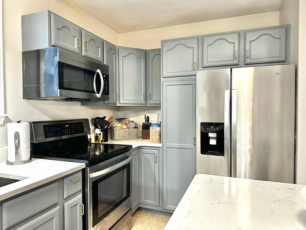 47-49 Botolph Street, Unit 49 Quincy, MA 02171 - Photo 7 of 14 a kitchen with stainless steel appliances granite countertop a refrigerator a stove and a sink with cabinets