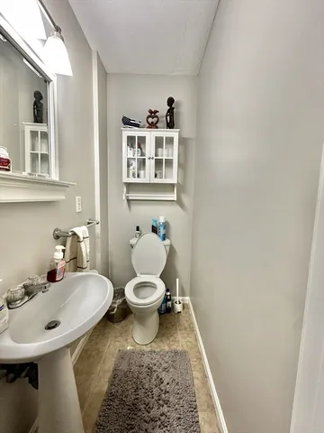 a bathroom with a sink a toilet and a mirror