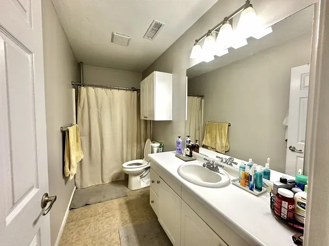 a bedroom with a bed and two windows