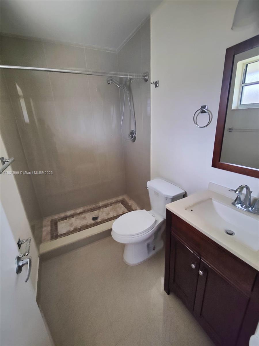 786 Northwest 103rd Terrace, Unit 202 Pembroke Pines, FL 33026 - Photo 3 of 10 a bathroom with a toilet sink vanity and mirror