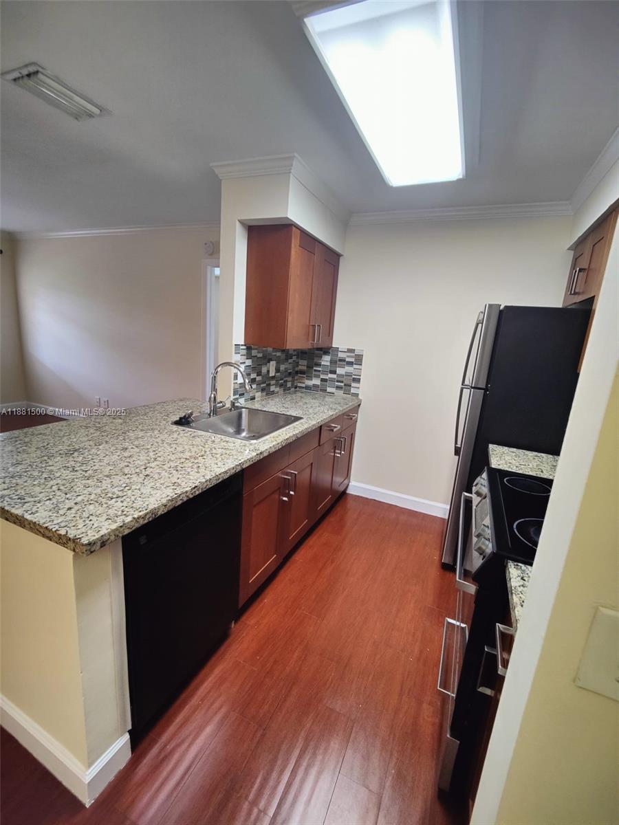 786 Northwest 103rd Terrace, Unit 202 Pembroke Pines, FL 33026 - Photo 9 of 10 a kitchen with stainless steel appliances granite countertop a sink stove and refrigerator