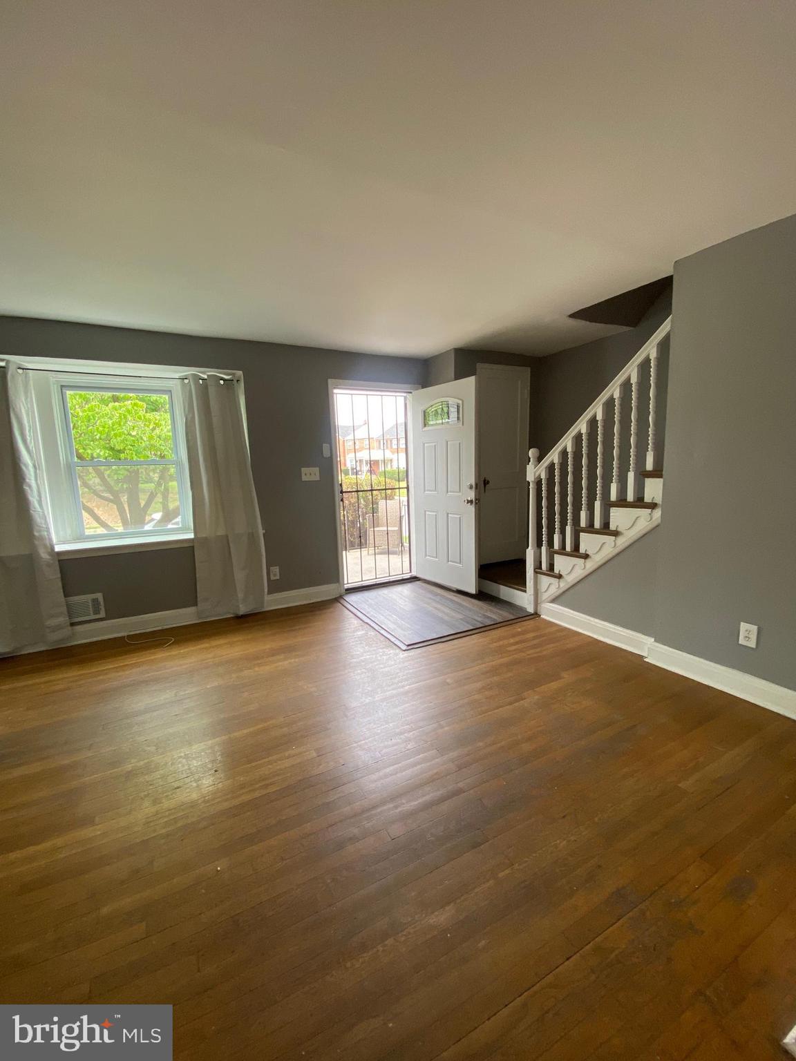 5757 Edgepark Road Baltimore, MD 21239 - Photo 5 of 44 a view of an empty room with wooden floor and a window