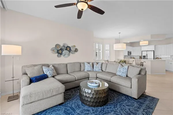 a living room with furniture kitchen view and a chandelier