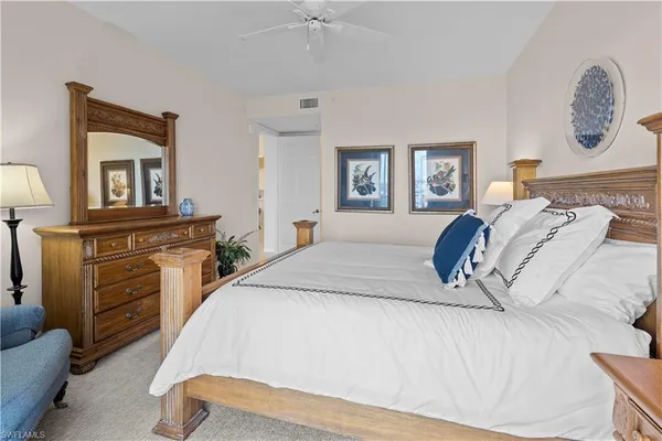 a spacious bedroom with a bed and a chandelier