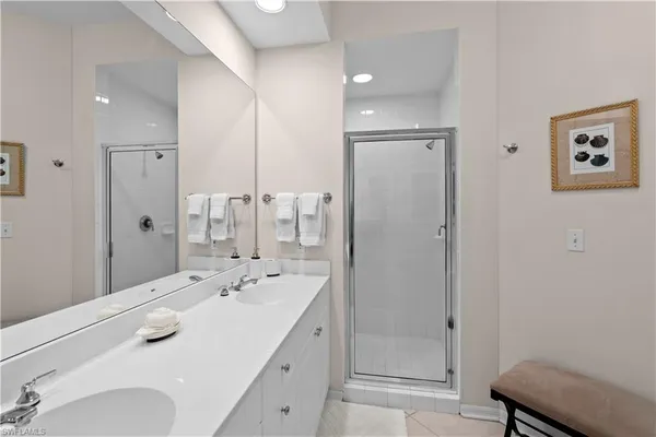 a bathroom with a double vanity sink mirror and shower