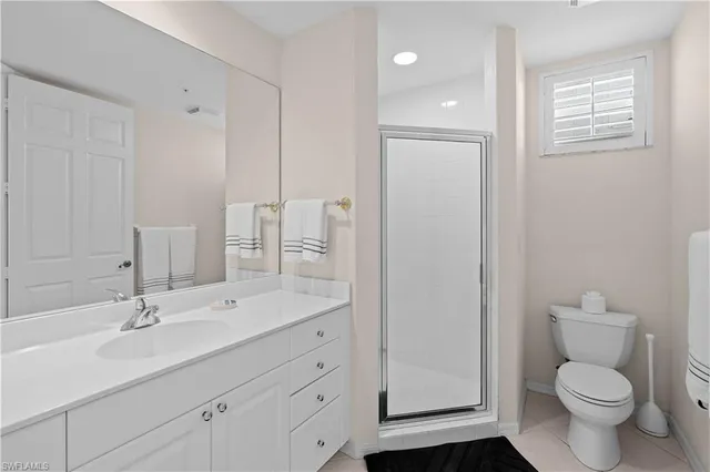 a bathroom with a toilet a sink a mirror and vanity