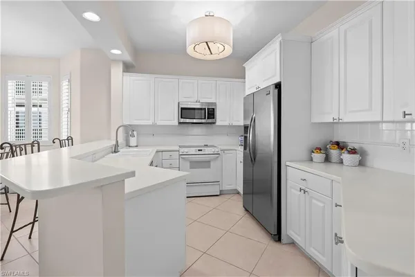 a kitchen with white cabinets and stainless steel appliances
