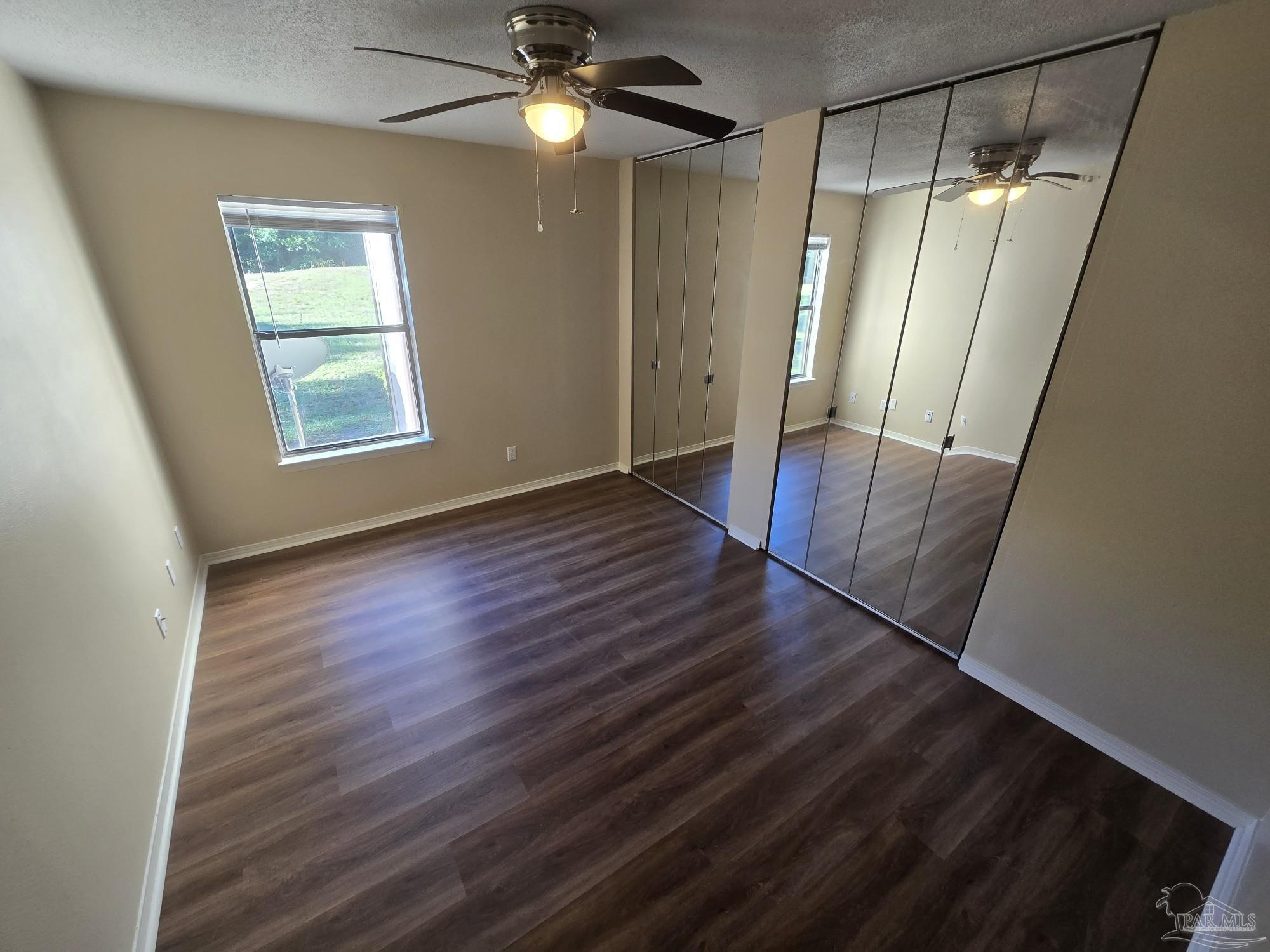2303 West Michigan Avenue, Unit B10 Pensacola, FL 32526 - Photo 7 of 25 an empty room with wooden floor fan and window