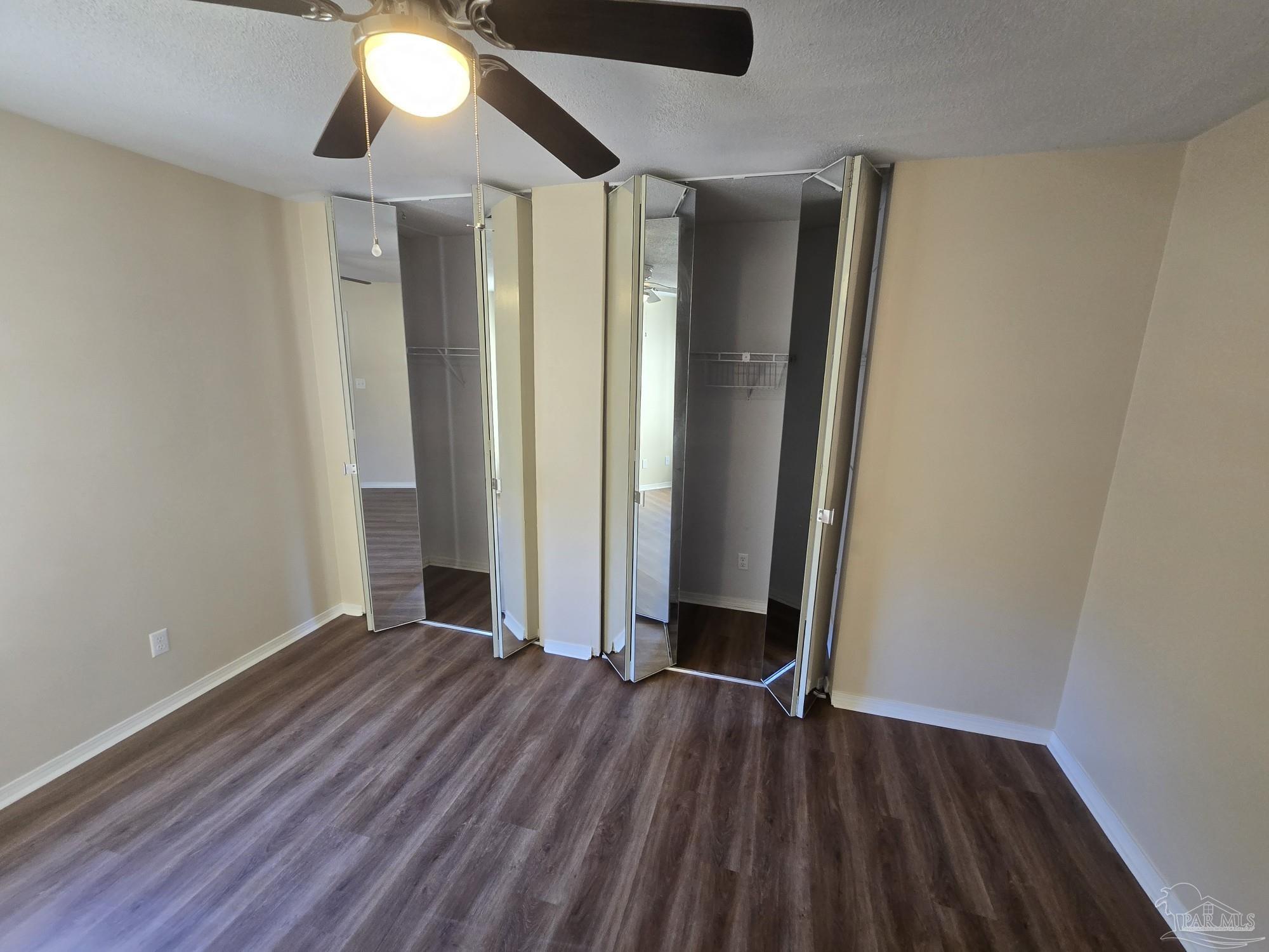 2303 West Michigan Avenue, Unit B10 Pensacola, FL 32526 - Photo 9 of 25 an empty room with wooden floor and windows
