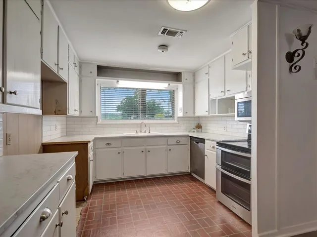 a kitchen with a sink stove and microwave