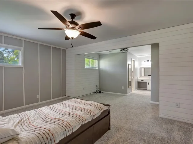 a bedroom with a large bed and a chandelier