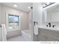 78 Main Street Tappan, NY 10983 - Photo 12 of 25 a bathroom with a bathtub a sink a window and a mirror