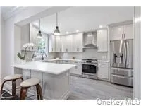 a kitchen with kitchen island a counter top space a sink stainless steel appliances and cabinets