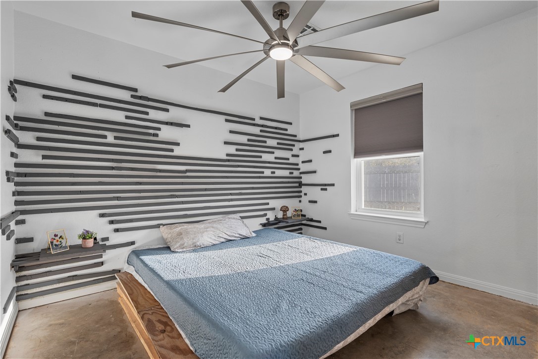 1101 East Walnut Street Waco, TX 76704 - Photo 14 of 17 a bedroom with a bed and a chandelier