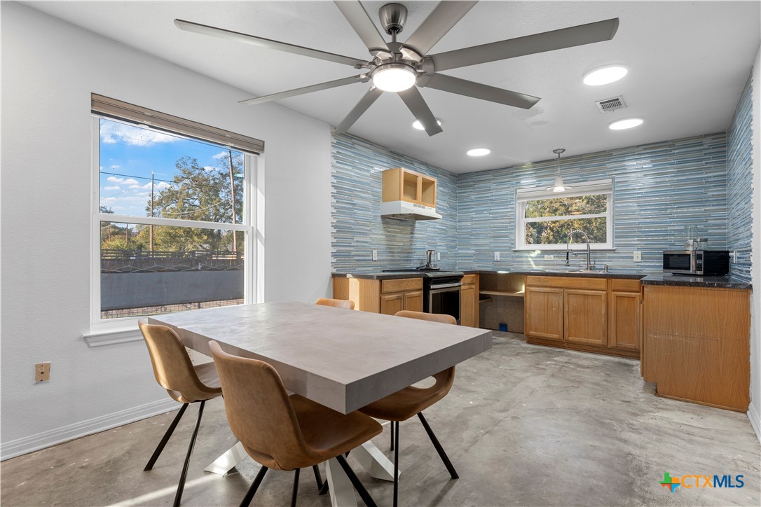1101 East Walnut Street Waco, TX 76704 - Photo 9 of 17 a kitchen with a table chairs microwave and cabinets