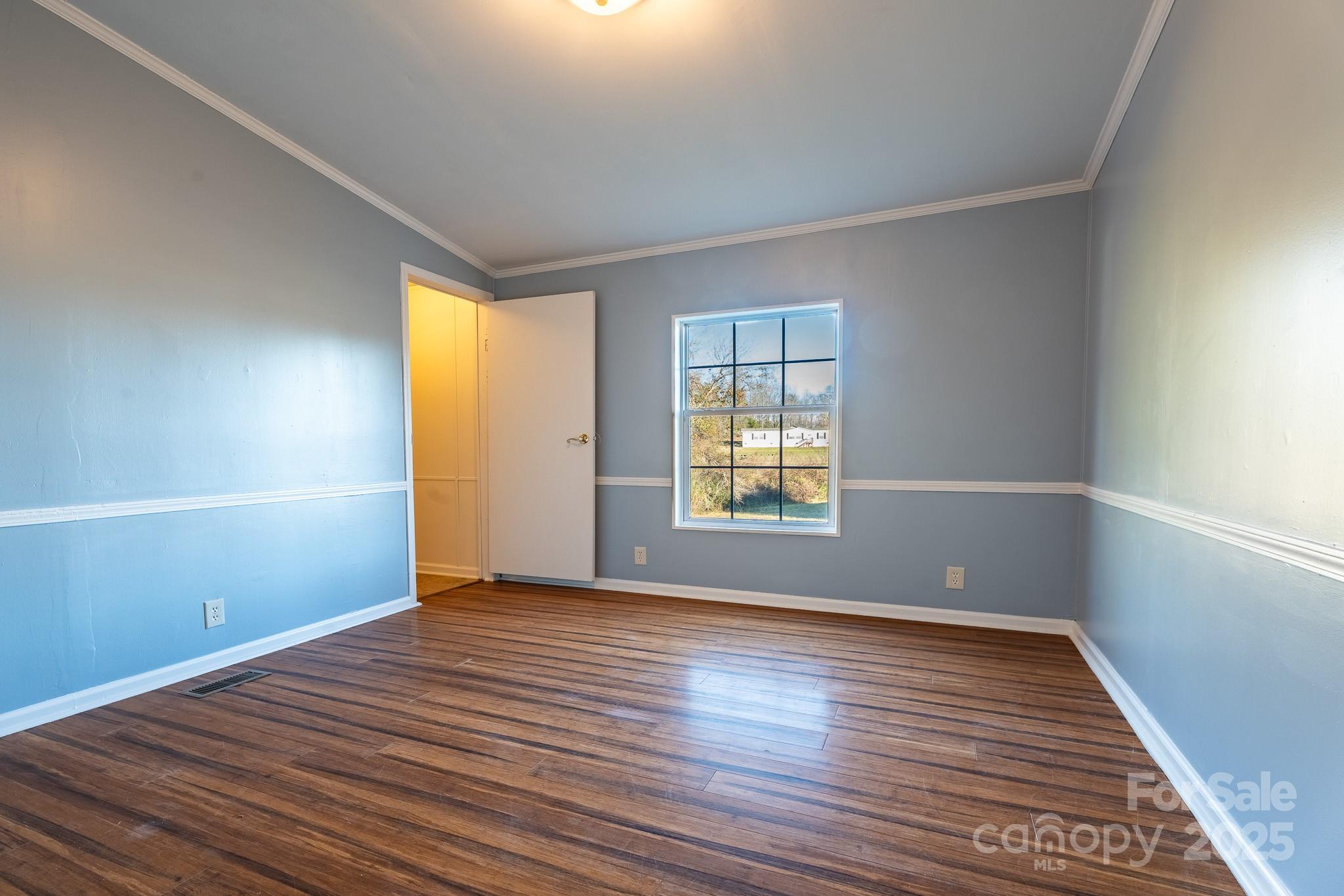 964 Lavender Road Grover, NC 28073 - Photo 8 of 26 an empty room with wooden floor and windows