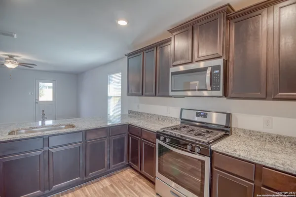a kitchen with cabinets stove top oven and sink