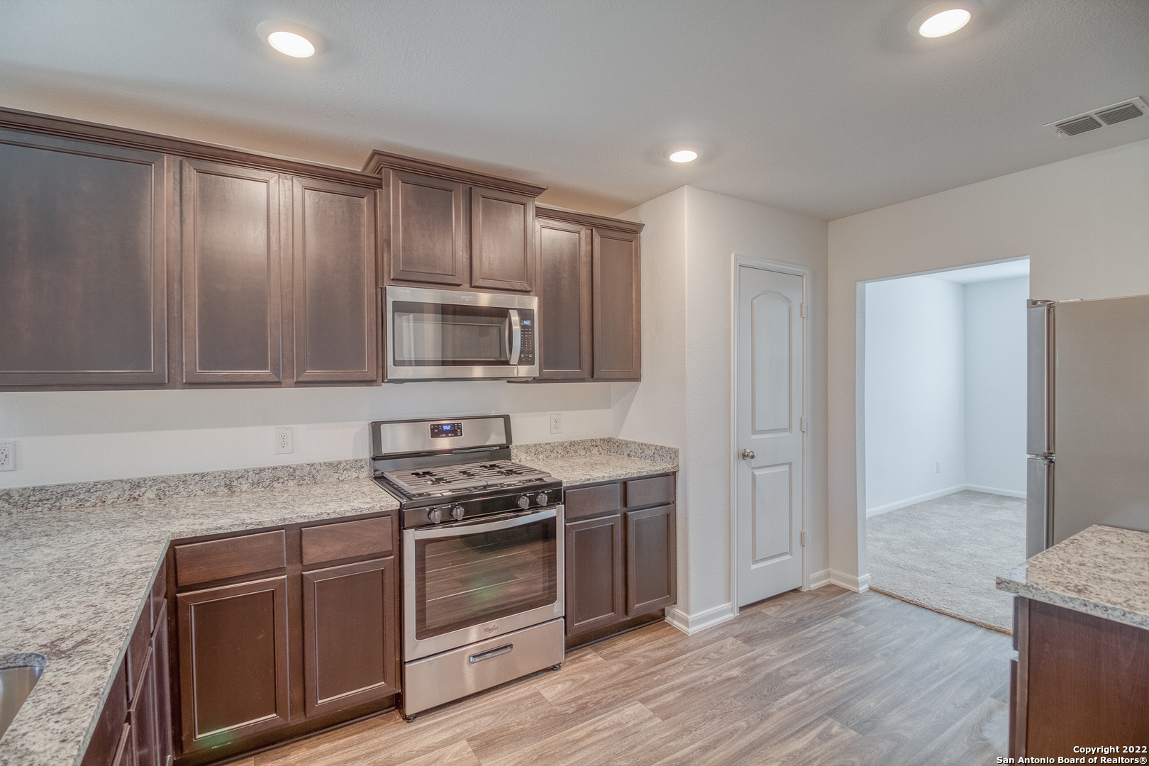 3055 Jackson Summit Converse, TX 78109 - Photo 12 of 31 a kitchen with wooden cabinets and stainless steel appliances