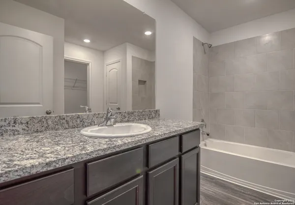 a bathroom with a granite countertop sink and a mirror