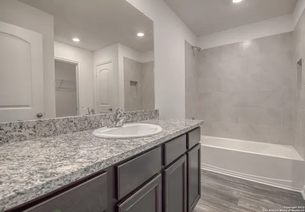 a bathroom with a granite countertop sink and a mirror