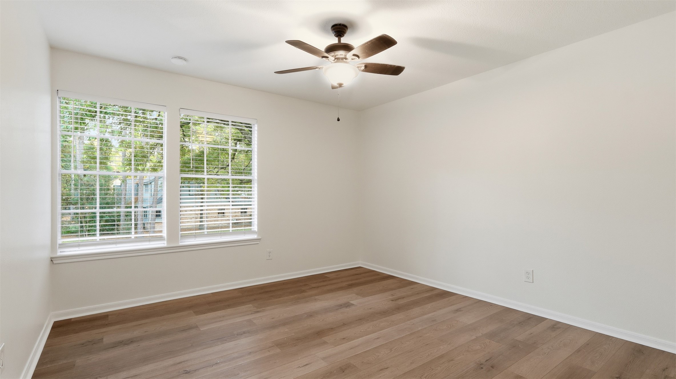 2715 Wild Ridge Drive Kingwood, TX 77339 - Photo 27 of 32 an empty room with a chandelier fan and windows