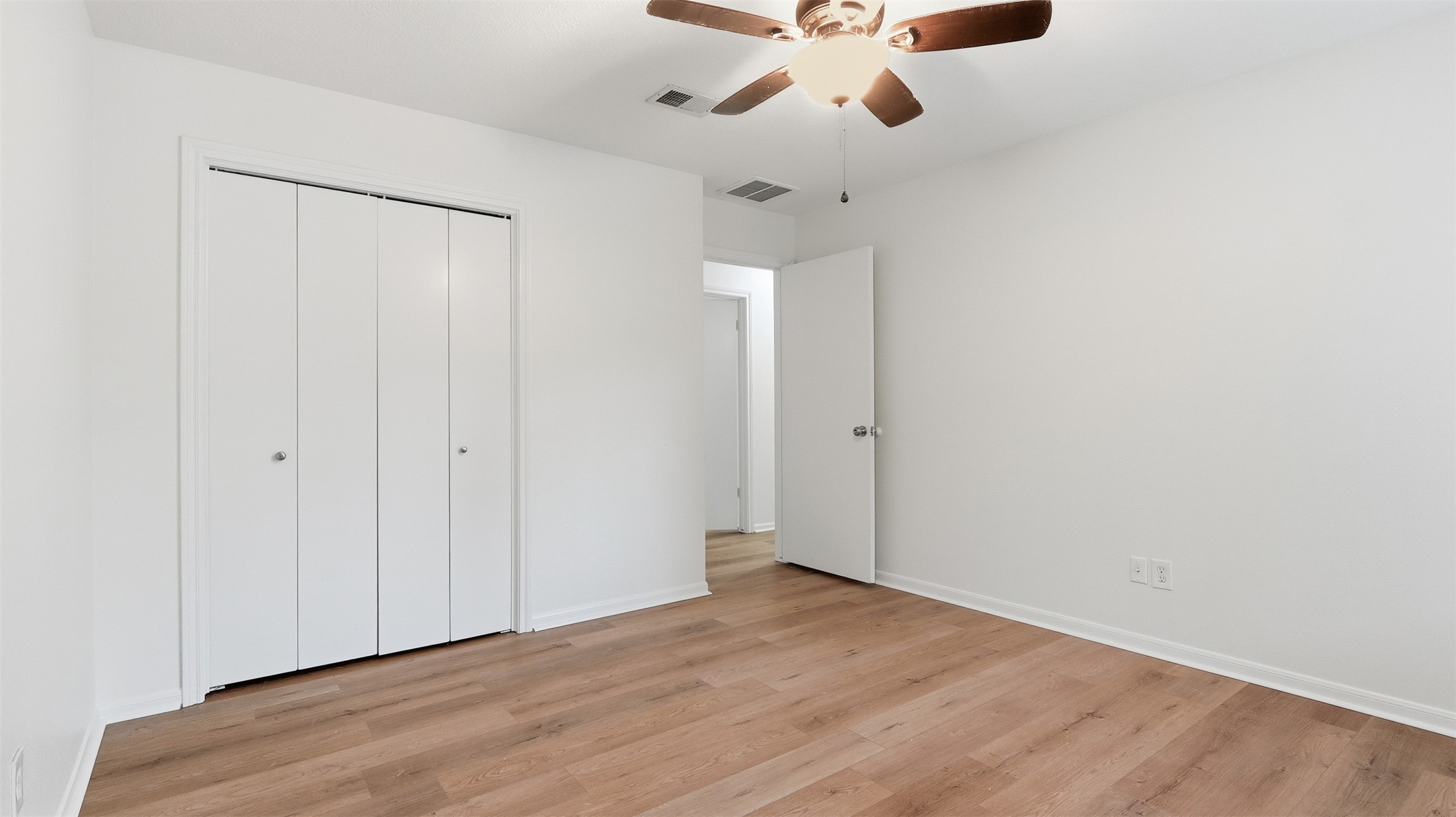 2715 Wild Ridge Drive Kingwood, TX 77339 - Photo 28 of 32 an empty room with wooden floor fan and windows