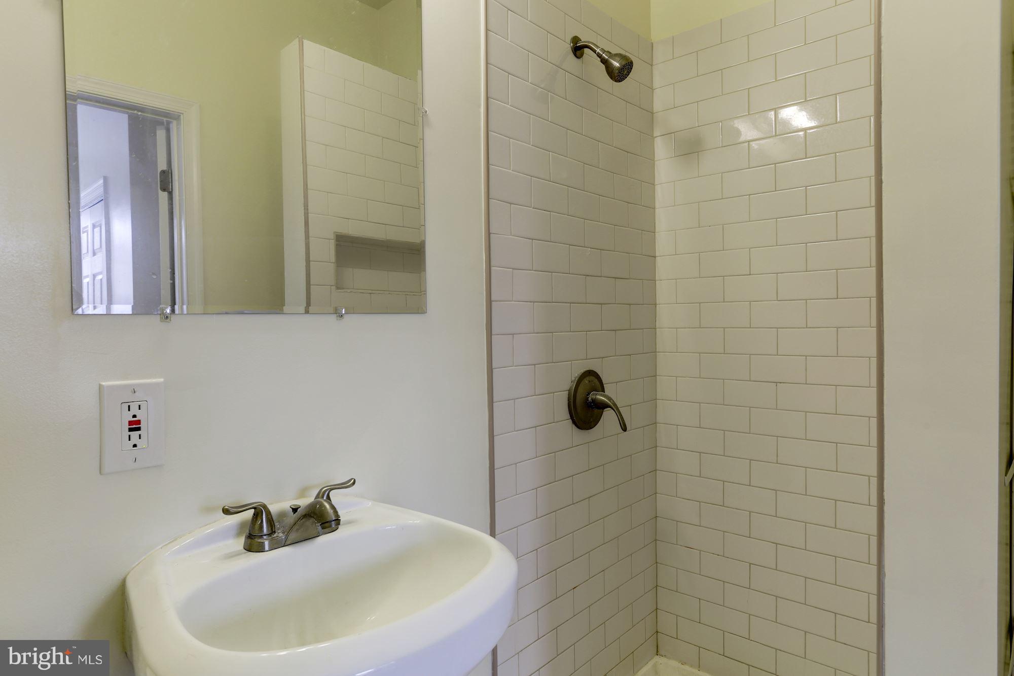 727 13th Street Northeast Washington, DC 20002 - Photo 18 of 27 a bathroom with a sink a window and shower