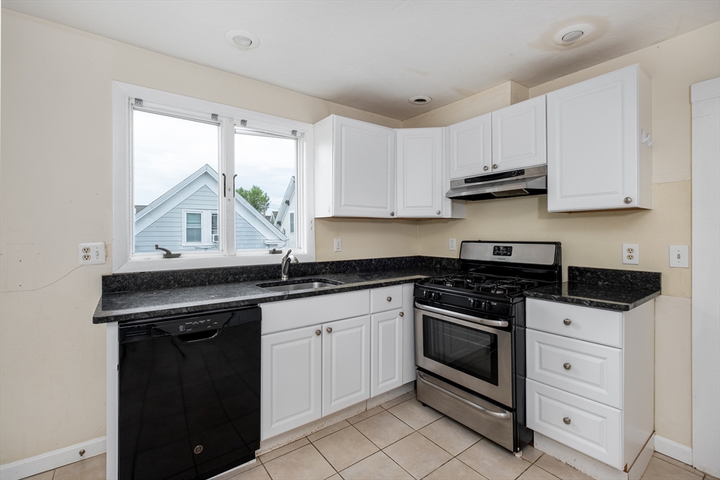 12 Kilby Street, Unit 2R Somerville, MA 02143 - Photo 1 of 19 a kitchen with granite countertop white cabinets and white appliances