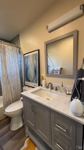 a bathroom with a granite countertop sink mirror vanity and toilet