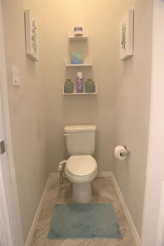 a white toilet sitting next to a shower