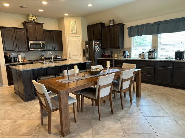 a large kitchen with a table and chairs